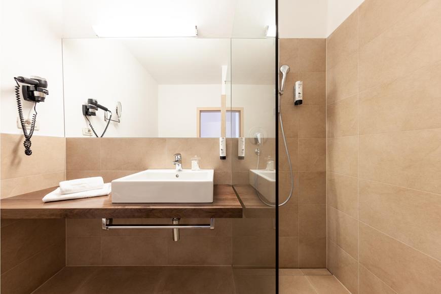 Badezimmer mit Waschbecken und Dusche - Einzelzimmer