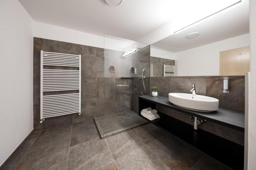 Badezimmer mit Dusche der Suite+ Design
